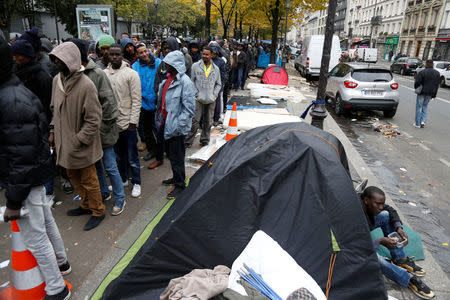Migrants queue for a free meal distributed by the Adventist Development and Relief Agency International (ADRA) humanitarian agency on a street near Stalingrad metro station in Paris, France, October 28, 2016. REUTERS/Charles Platiau