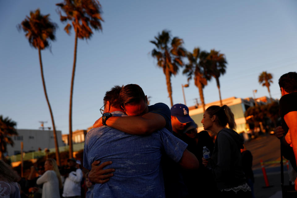 <p>People embrace during a memorial for Rachael Parker and Sandy Casey, victims of the October 1st Las Vegas Route 91 music festival mass shooting, in Manhattan Beach, Calif., Oct. 4, 2017. (Photo: Patrick T. Fallon/Reuters) </p>