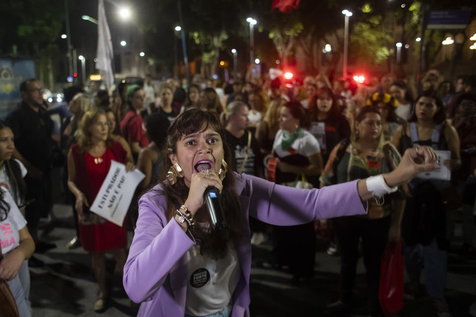 An abortion rights activist speaks into a microphone during a protest against an anti-abortion bill in Brazil's Congress, in Rio de Janeiro, Thursday, June 13, 2024. (AP Photo/Bruna Prado)