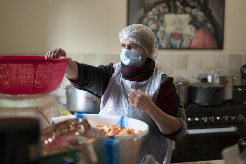 Volunteer Hardeep SIngh helps in the kitchen as members of the Preston Windrush Covid Response team prepare West Indian meals, at the Xaverian Sanctuary, in Preston, England, Friday Feb. 19, 2021. Once a week chief coordinator Glenda Andrew and her team distribute meals to people in Preston and surrounding communities in northwestern England that have recorded some of the U.K.’s highest coronavirus infection rates. The meal program grew out of Andrew’s work with Preston Windrush Generation & Descendants, a group organized to fight for the rights of early immigrants from the Caribbean and other former British colonies who found themselves threatened with deportation in recent years. (AP Photo/Jon Super)