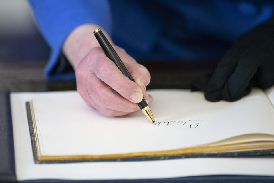 The Queen signs the guest book at the RAF Club in London back in 2018. (WPA Pool/Getty Images)