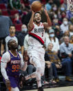 Portland Trail Blazers guard CJ McCollum shoots in front of Phoenix Suns forward Jae Crowder during the first half of an NBA basketball game in Portland, Ore., Saturday, Oct. 23, 2021. (AP Photo/Craig Mitchelldyer)