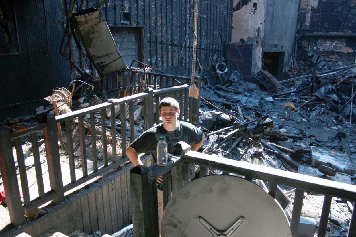 FILE - This 2009 photo taken inside the charred interior of the Georgia Theatre in Athens, Ga. shows "Athens Burning" documentary co-director Andrew Haynes standing amid the debris.