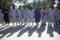 Afghan Taliban prisoners line up after their release from Bagram Prison in Parwan province, Afghanistan, Tuesday, May 26, 2020. The Afghan government freed hundreds of prisoners, its single largest prisoner release since the U.S. and the Taliban signed a peace deal earlier this year that spells out an exchange of detainees between the warring sides. (AP Photo/ Rahmat Gul)