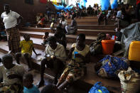 Displaced families, victims of Cyclone Idai, eat lunch at the Samora Machel Secondary School which is being used to house victims of the floods in Beira, Mozambique, Sunday March 24, 2019. The death toll has risen above 750 in the three southern African countries hit 10 days ago by the cyclone storm, as workers restore electricity, water and try to prevent outbreak of cholera, authorities said Sunday. (AP Photo/Phill Magakoe)