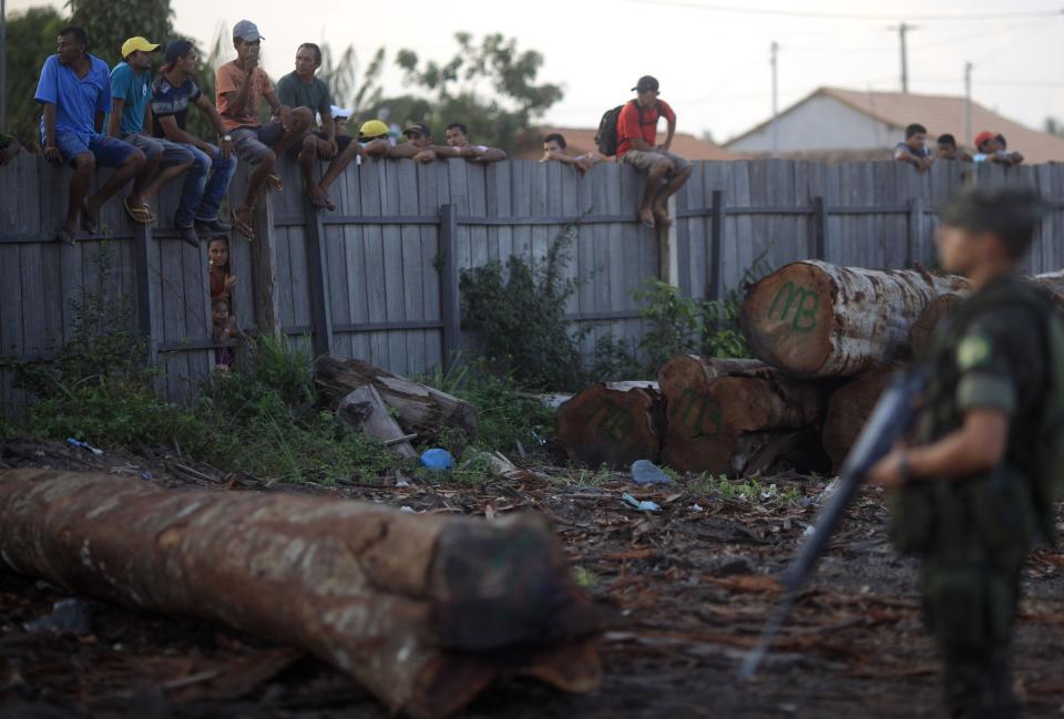 Brazilian Army soldiers guard a sawmill as residents, most of whom work at the mill, observe them in Nova Esperanca do Piria