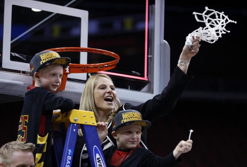 Maryland coach Brenda Frese holds up the net while joined by her sons, Tyler, left, and Markus, after Maryland defeated Louisville 76-73 in a regional final of the NCAA women's college basketball tournament Tuesday, April 1, 2014, in Louisville, Ky. (AP Photo/John Bazemore)