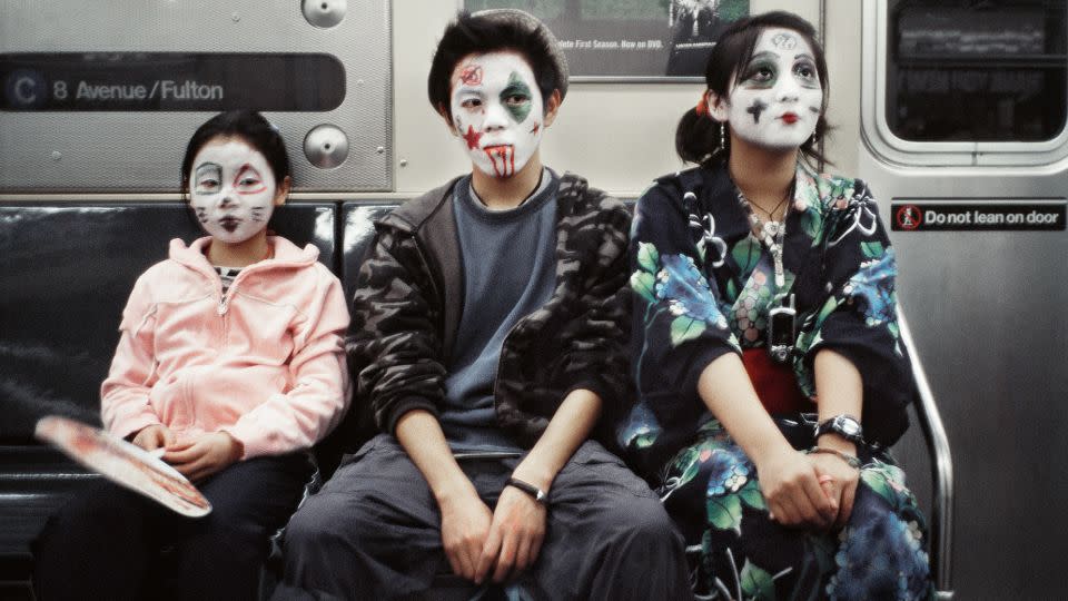 A family in face paint rides the C train. - Seymour Licht