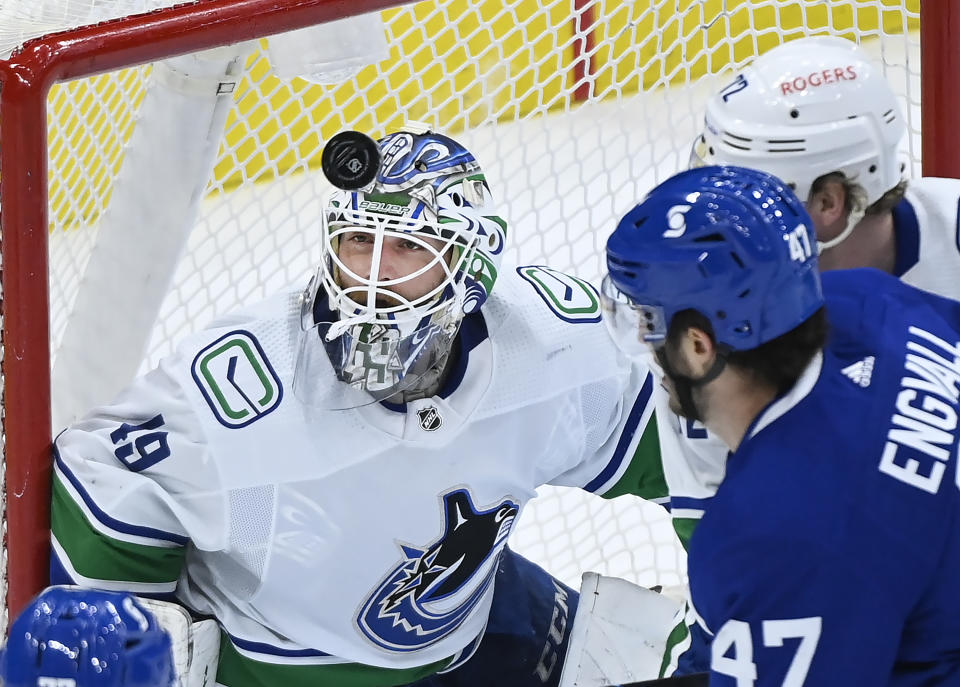 FILE - Vancouver Canucks goaltender Braden Holtby (49) eyes the loose puck during the first period of an NHL hockey game against the Toronto Maple Leafs in Toronto, in this Thursday, April 29, 2021, file photo. At right is Toronto forward Pierre Engvall (47). Carey Price's questionable injury status clouds the Seattle Kraken's selection process in their expansion draft. The Montreal Canadiens goaltender with connections to the Pacific Northwest could become the cornerstone and face of the franchise if picked. Stanley Cup champion and 2016 Vezina Trophy winner Braden Holtby would also fit that bill. (Nathan Denette/Canadian Press via AP, File)