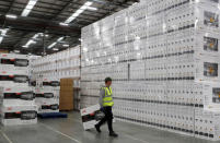 A worker drags carries a JVC television past Sony televisions at the PC World and Carphone Warehouse distribution centre in Newark, Britain November 21, 2017. REUTERS/Darren Staples