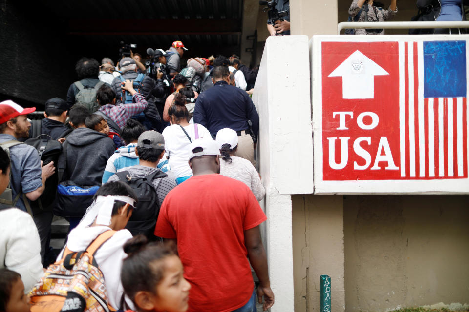 Caravan members pass by signs marking the way to the United States border.