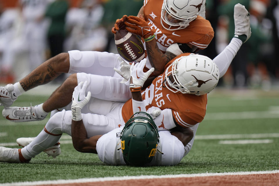 Texas linebacker Trevell Johnson, top, and defensive back Terrance Brooks, center, break up a pass intended for Baylor wide receiver Jaylen Ellis, bottom, during the first half of an NCAA college football game in Austin, Texas, Friday, Nov. 25, 2022. (AP Photo/Eric Gay)