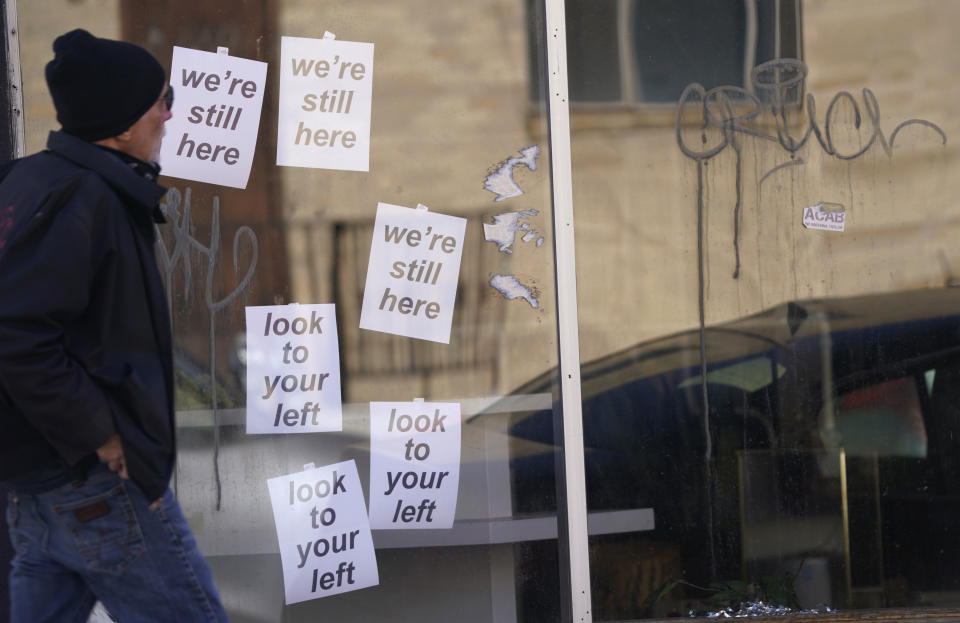 A customer heads into a store one block south of the State Capitol, Tuesday, Jan. 19, 2021, in downtown Denver. Businesses around the statehouse are struggling because of the effects of the pandemic and now with the threat of violence around the Capitol on the inauguration day for President-elect Joe Biden. (AP Photo/David Zalubowski)