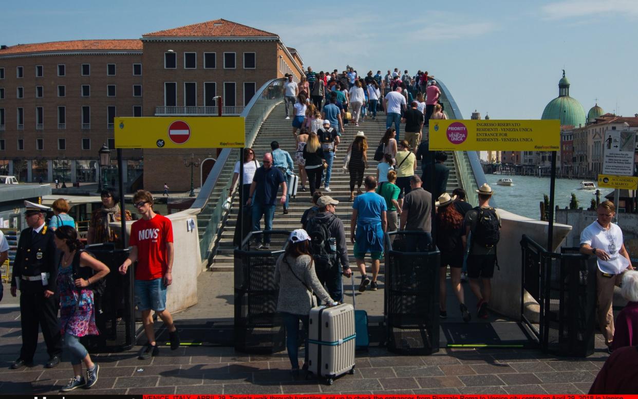 Tourists walk through metal barriers at the foot of a bridge in Piazzale Roma in Venice - Getty Images Europe