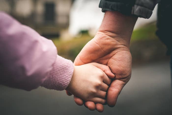 A child and an adult holding hands