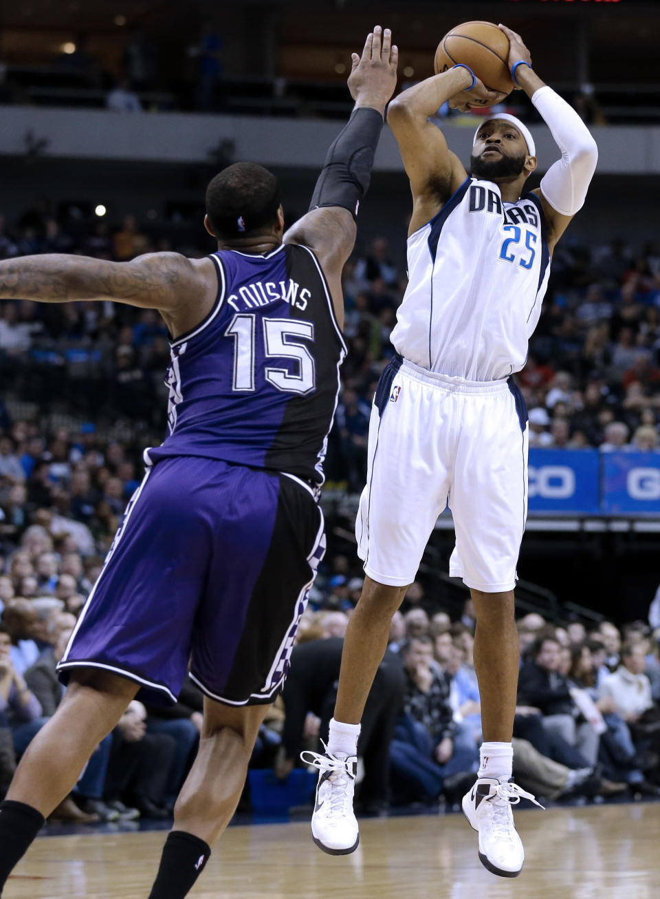 Dallas Mavericks' Vince Carter (25) shoots a 3-point basket as Sacramento Kings' DeMarcus Cousins (15) defends in the second half of an NBA basketball game Wednesday, Feb. 13, 2013, in Dallas. The Mavericks won 123-100. (AP Photo/Tony Gutierrez)