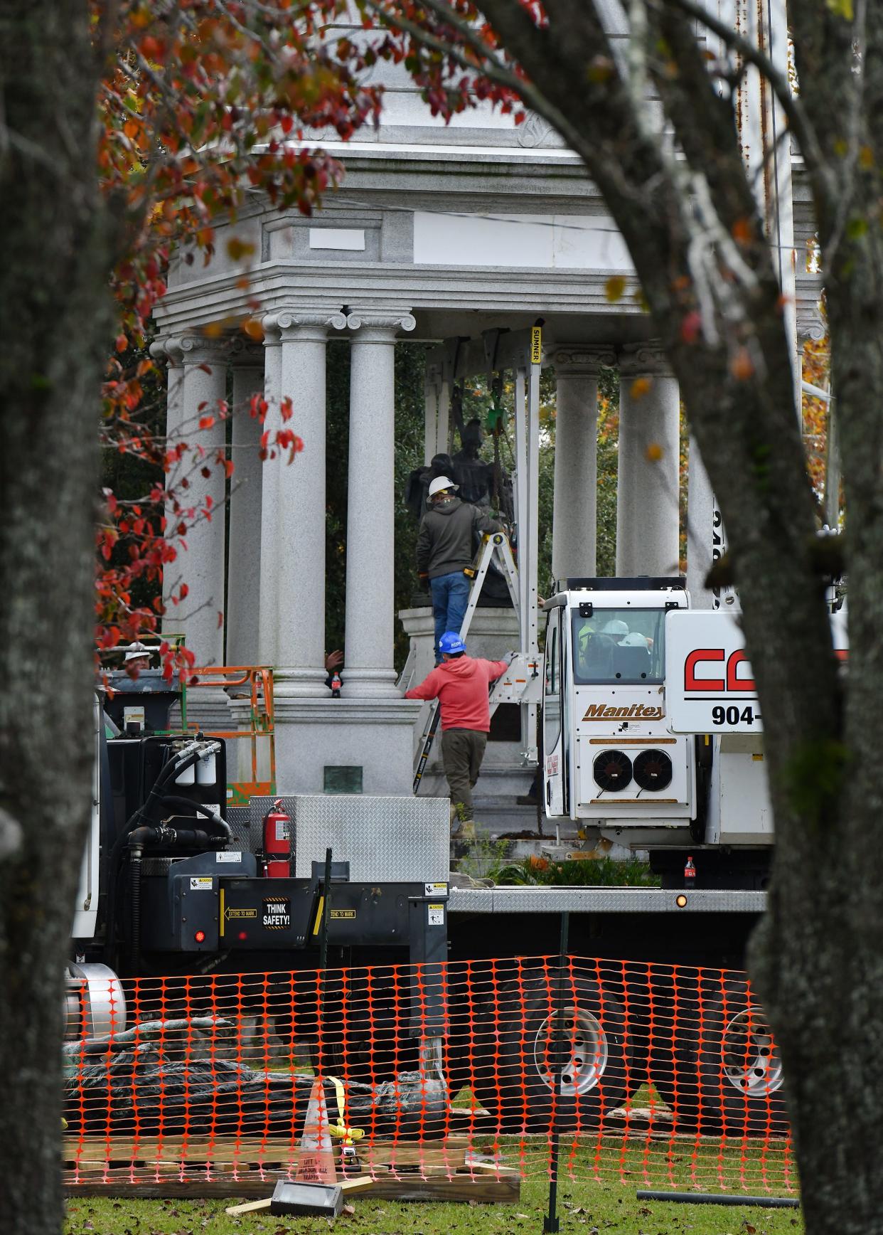 Engravings over the facade with the dates 1861 and 1865 and "A Tribute to the Women of the Southern Confederacy" were covered by workers as crews removed the Confederate statues, plaques and pedestal from the "Women of the Southland" monument in Jacksonville's Springfield Park on Wednesday.