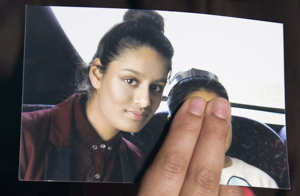 A family member of Shamima Begum holds a picture of the British girl, left, while being interviewed by the media in London, on February 22, 2015.