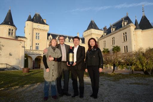 Chinese billionaire Lam Kok (2nd R) and his spouse pose alongside the French former owner of the Chateau de La Riviere, James Gregoire (2nd L), and his spouse in front of the castle in La Riviere, on December 20, 2013