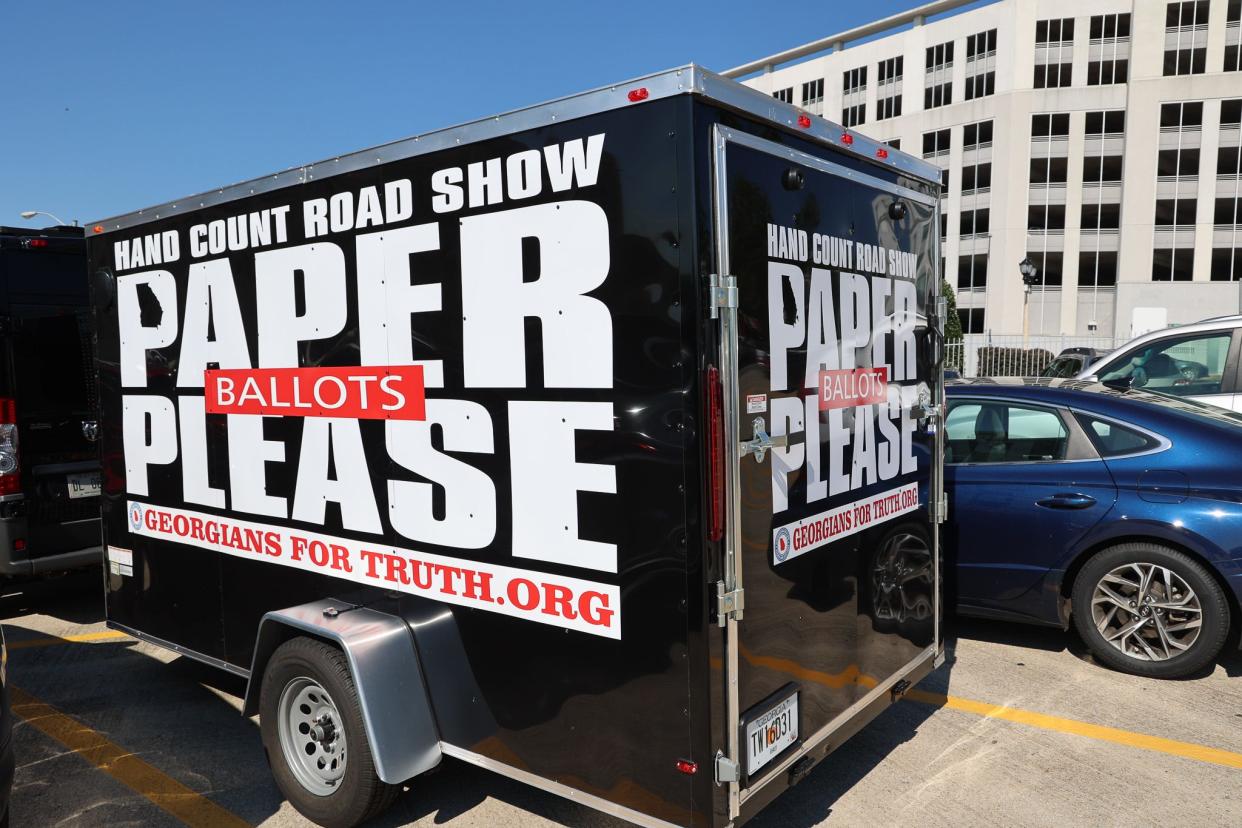 Outside the Georgia Capitol, a trailer pulled by activists trumpets their push for the state to use paper ballots in place of its electronic Dominion Voting System machines.