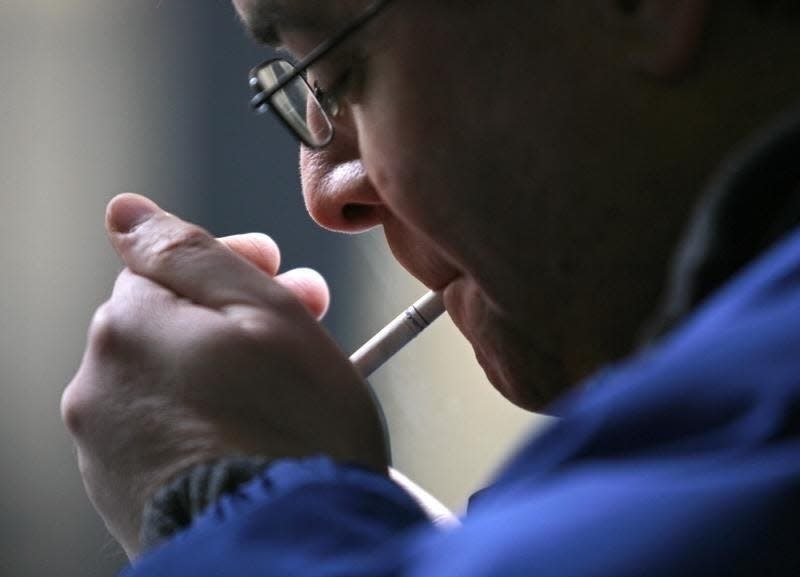 A smoker lights a cigarette in downtown Toronto February 19, 2007. REUTERS/J.P. Moczulski