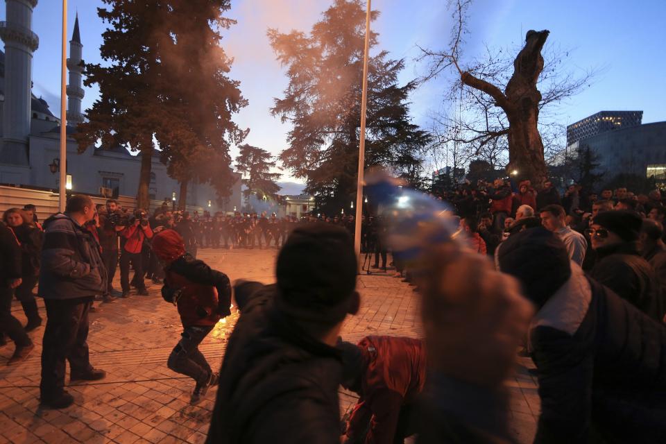 A young protester throws a plastic bottle during an antigovernment rally in Tirana, Tuesday, Feb. 26, 2019. Albanian opposition supporters have surrounded the parliament building and are demanding that the government resign, claiming it's corrupt and has links to organized crime. (AP Photo/Hektor Pustina)