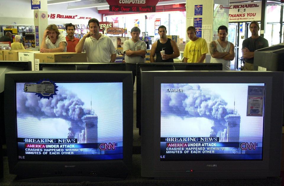 Customers at P.C. Richards in Yonkers, New York, watch news reports of terrorist attacks on the World Trade Center on Sept. 1, 2001.