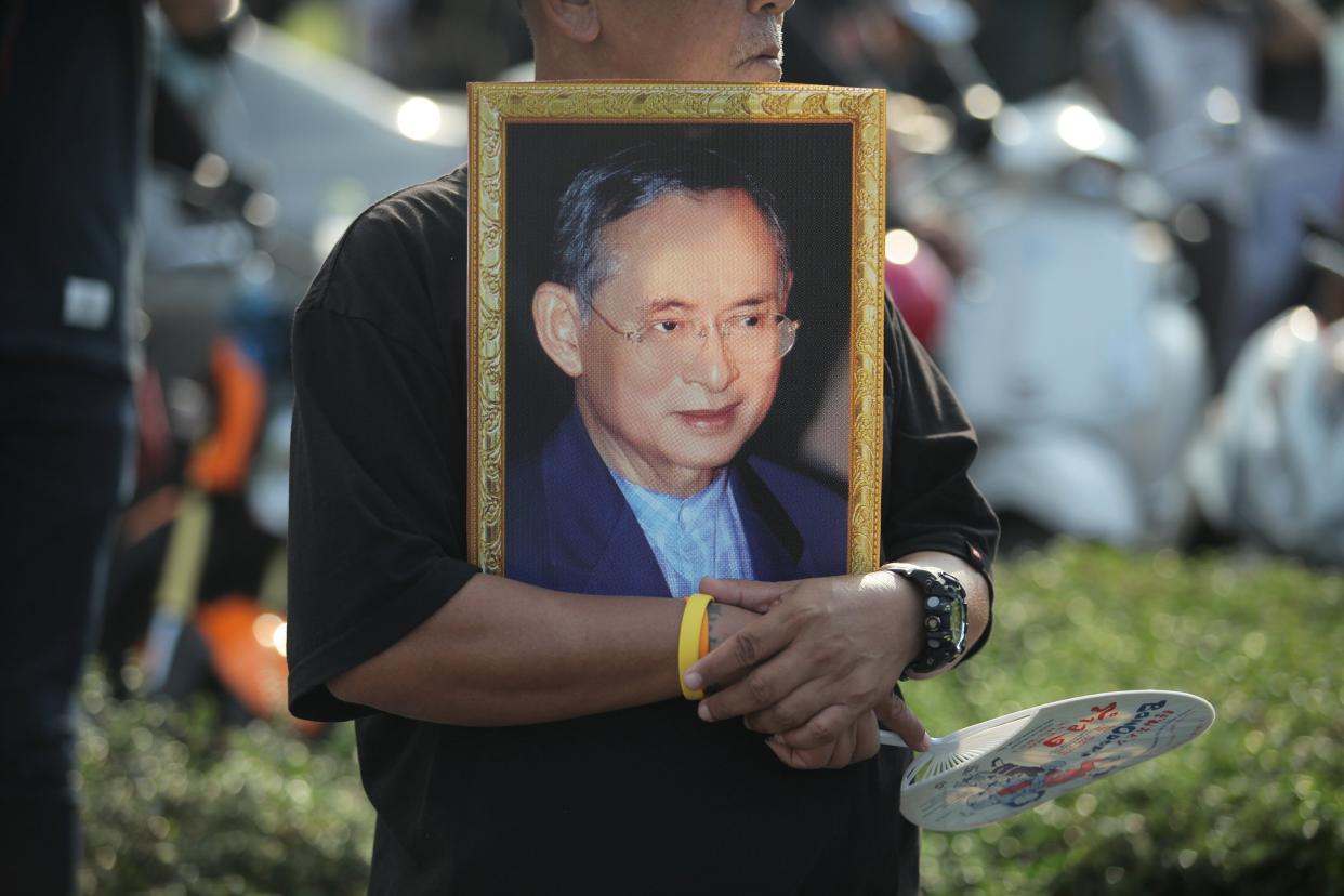 man hold the portrait of King Bhumibol Adulyadej