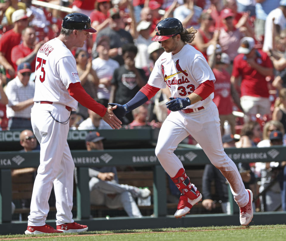St. Louis Cardinals' Brendan Donovan (33) is congratulated by third bas coach Ron 'Pop' Warner after hitting a three-run home run in the sixth inning of a baseball game against the Detroit Tigers, Sunday, May 7, 2023, in St. Louis. (AP Photo/Tom Gannam)