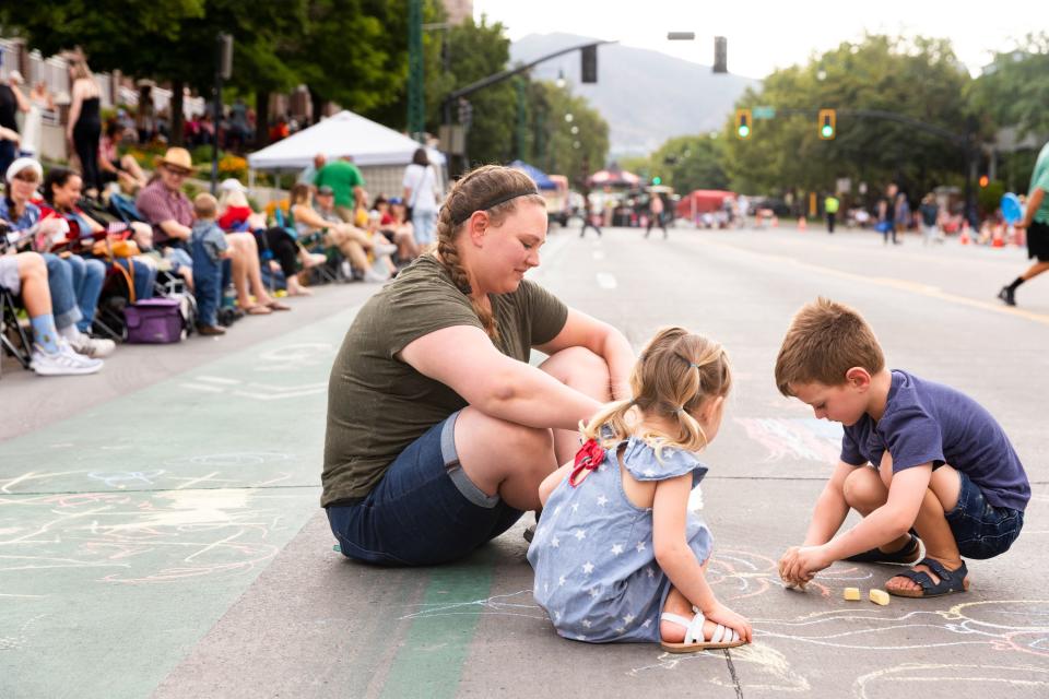Jacob, right, Emma, and their mom Rachelle Stucki draw chalk art on the parade route before the annual Days of ’47 Parade in Salt Lake City on Monday, July 24, 2023. | Megan Nielsen, Deseret News