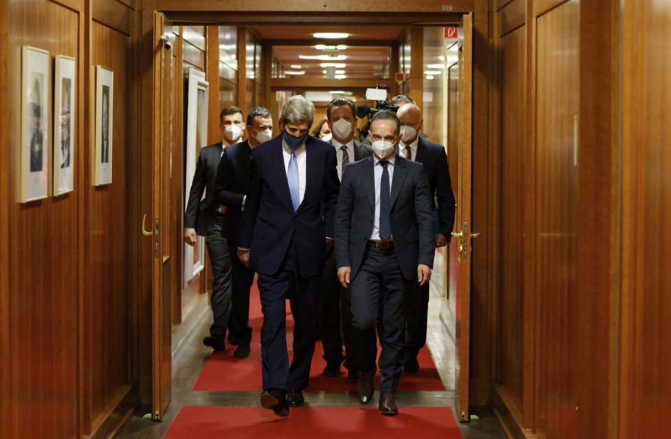 German Foreign Minister Heiko Maas, right, and the US' Special Presidential Envoy for Climate John Kerry, left, walk to a meeting at the Foreign Office in Berlin on Tuesday, May 18, 2021. (Odd Andersen/Pool Photo via AP)