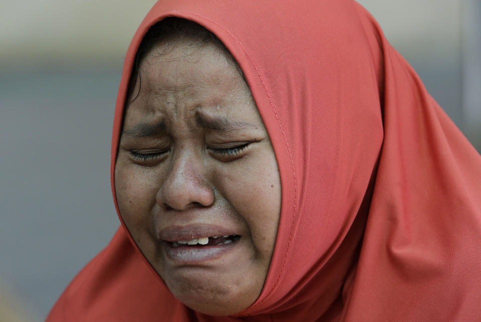A woman cries after learning that her daughter was one of those buried at a mass grave after being recovered in the massive earthquake and tsunami at Palu, Central Sulawesi, Indonesia Thursday, Oct. 4, 2018. Nearly a week after a magnitude 7.5 quake spawned a deadly tsunami on Indonesia’s island of Sulawesi, countless people have yet to find their loved ones _ both survivors and the dead. As of Thursday, the official death toll was 1,424, with 113 people missing. Many families, though, never registered their losses with police, and others have failed to identify them before they were buried anonymously in mass graves. (AP Photo/Aaron Favila)