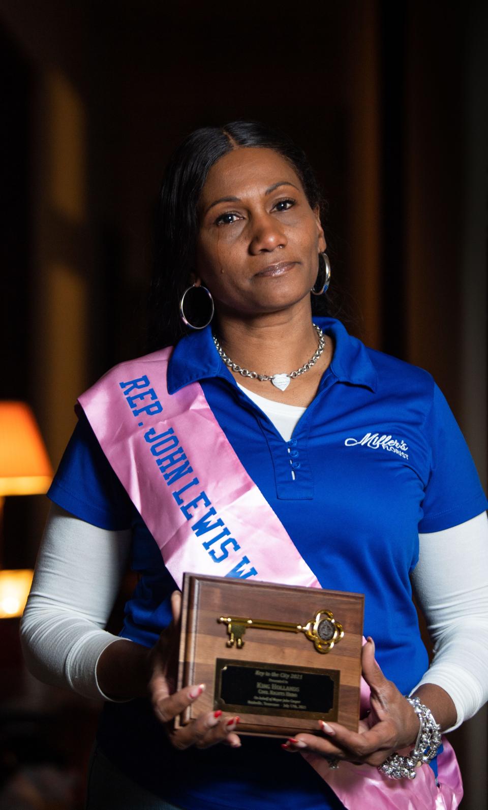 Kisha Turner, King Hollands, holds her father’s key to the city while wearing the sash he wore the day he received it in Nashville, Tenn., Friday, Jan. 5, 2024.