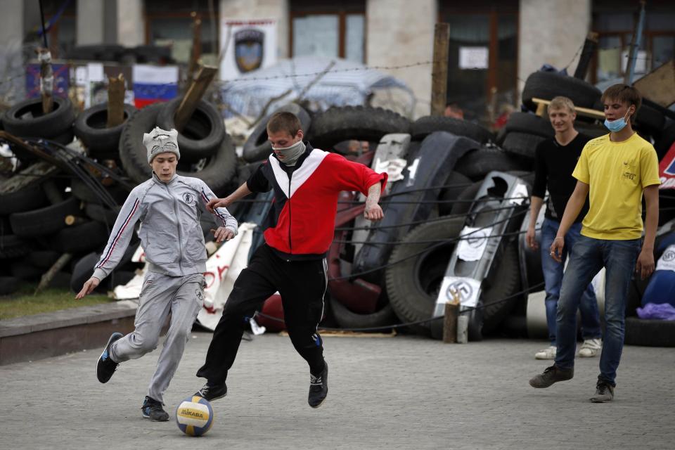 Pro-Russian protesters play soccer in front of a barricade outside a regional government building in Donetsk