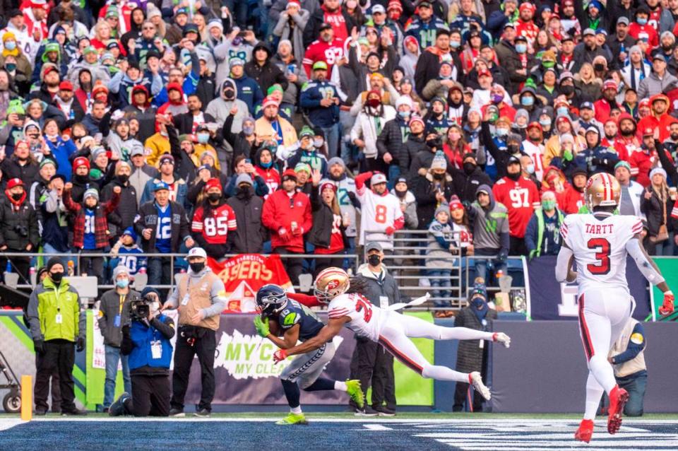 Seattle Seahawks wide receiver Tyler Lockett (16) pulls in a touchdown pass from quarterback Russell Wilson (3) as San Francisco 49ers cornerback Josh Norman (26) defends during the third quarter of an NFL game on Sunday at Lumen Field in Seattle.