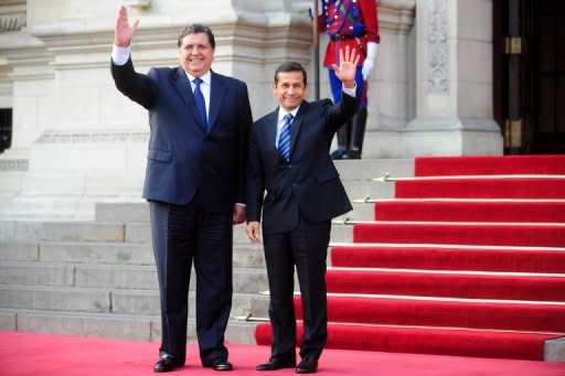 Peru's President-elect Ollanta Humala (R) and Peru's President Alan Garcia wave to the media before a private meeting at the government palace in Lima on June 17. Garcia on Saturday promised a peaceful transition for Humala, amid anti-mining violence the day before that left five people dead and 30 injured