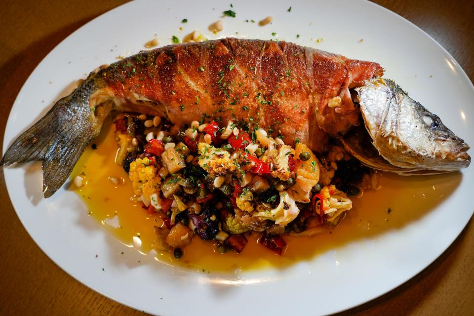 The whole branzino from Il Cervo is made with speck, cauliflower caponata, pine nuts, lemon olive oil, fennel and pollen.