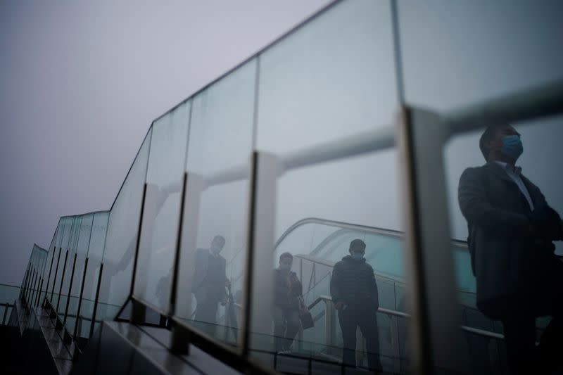 People wearing face masks descend a stairwell following the coronavirus disease (COVID-19) outbreak, in Shanghai
