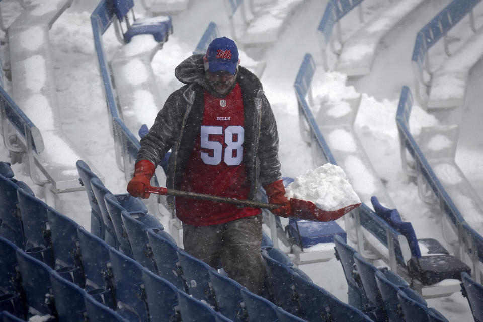 Un trabajador ayuda a remover nieve del estadio Highmark en Orchard Park, Nueva York, el domingo 14 de enero de 2024. (AP Foto/ Jeffrey T. Barnes)