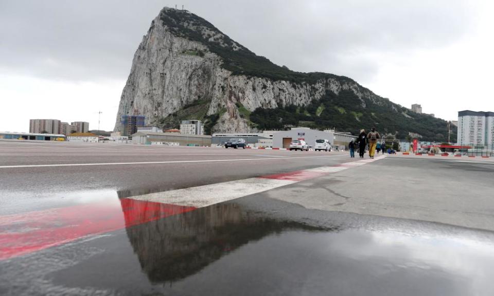 Pedestrians cross the asphalt at Gibraltar international airport in front of the Rock, near the border with Spain.