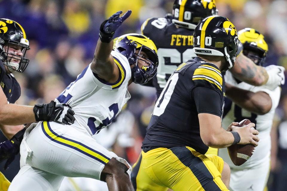 Michigan defensive end Jaylen Harrell pressures Iowa quarterback Deacon Hill during the first half of the Big Ten championship game at Luca Oil Stadium in Indianapolis, Ind. on Saturday, Dec. 2, 2023.