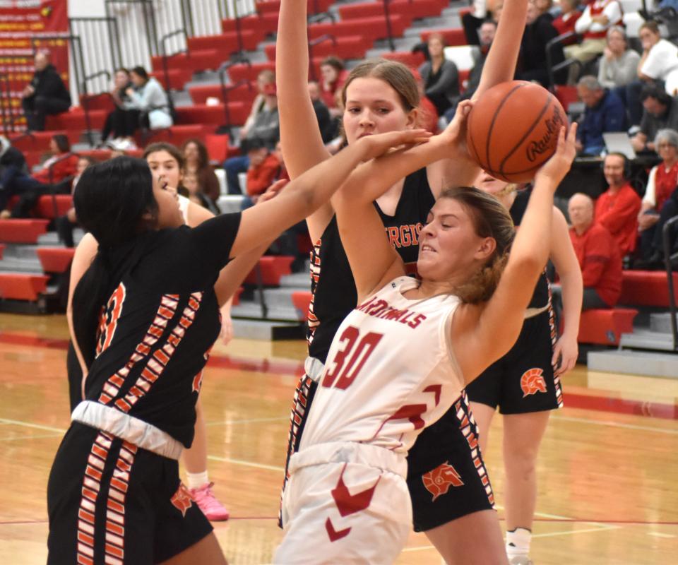 Coldwater freshman Coley Burkhardt (30) battles a host of Trojan defenders for a rebound Tuesday night. Burkhardt led all scorers with 21 points in the victory