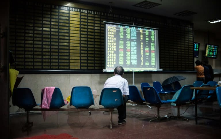 An investor sit in front of a screen showing stock market movements in a brokerage house in Shanghai on July 6, 2015