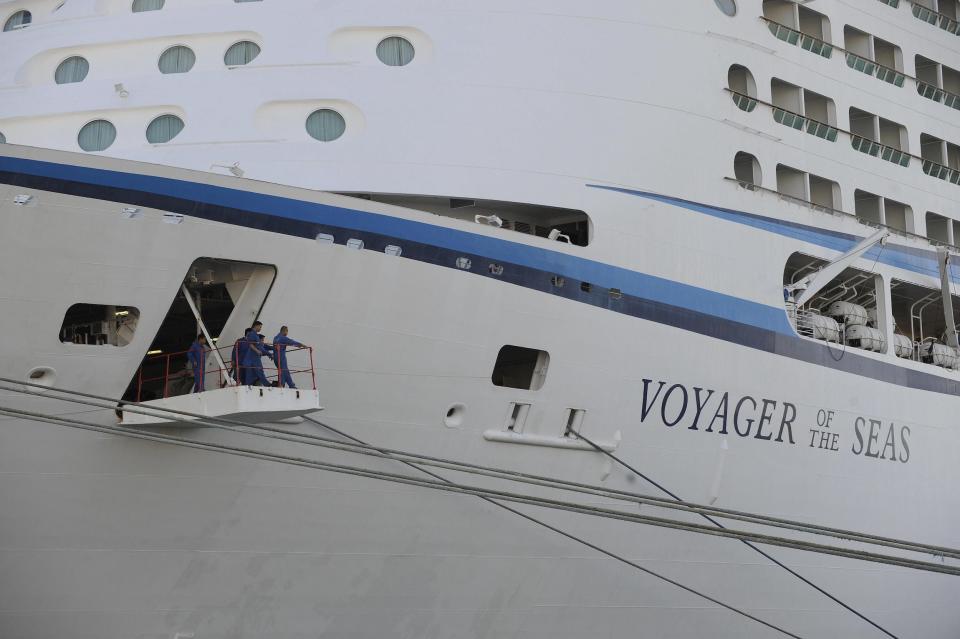 Crew members of the cruise boat 'Voyager of the Seas' look out from the gangplank