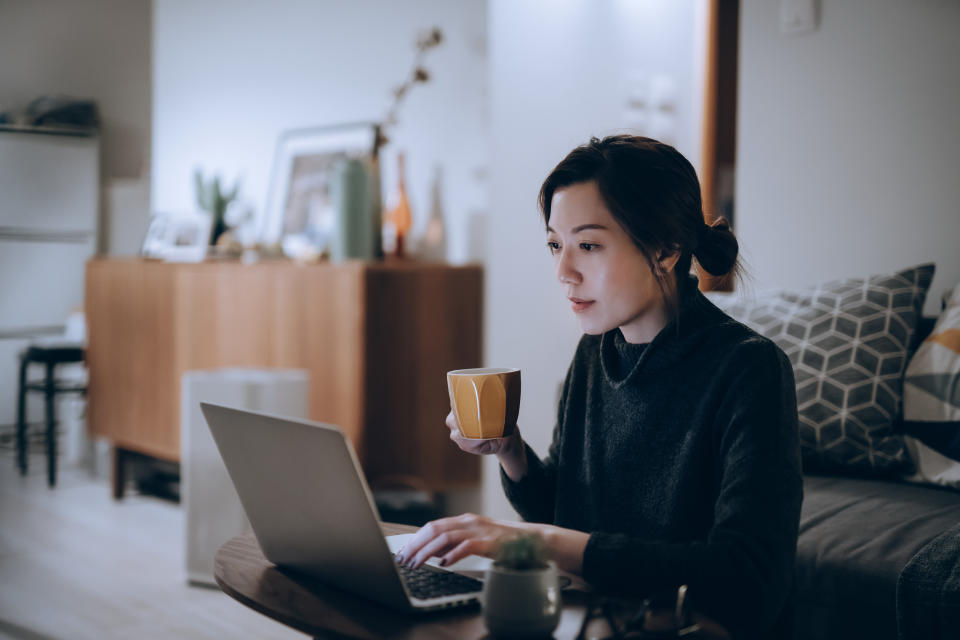 Busy concentrated young Asian woman remote-working from home.