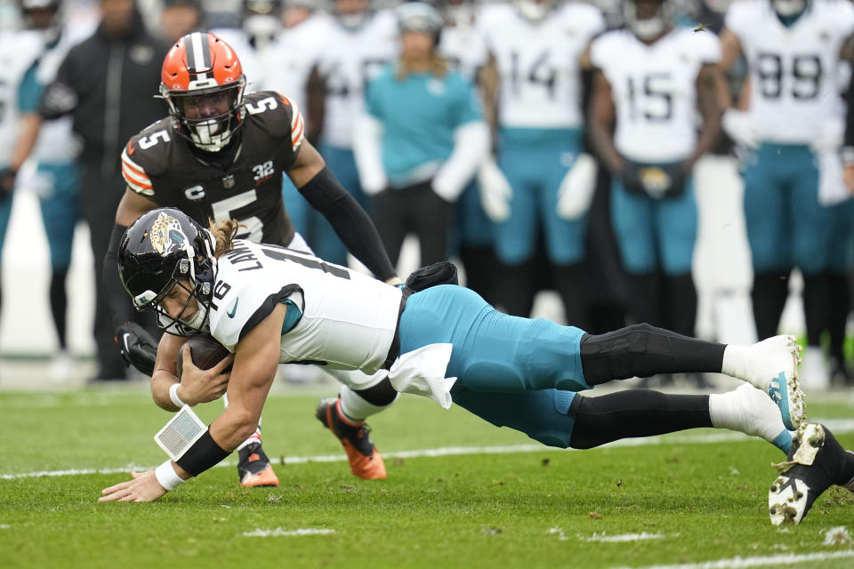 Jacksonville Jaguars quarterback Trevor Lawrence (16) falls after a scramble during the first half of an NFL football game against the Cleveland Browns, Sunday, Dec. 10, 2023, in Cleveland. (AP Photo/Sue Ogrocki)