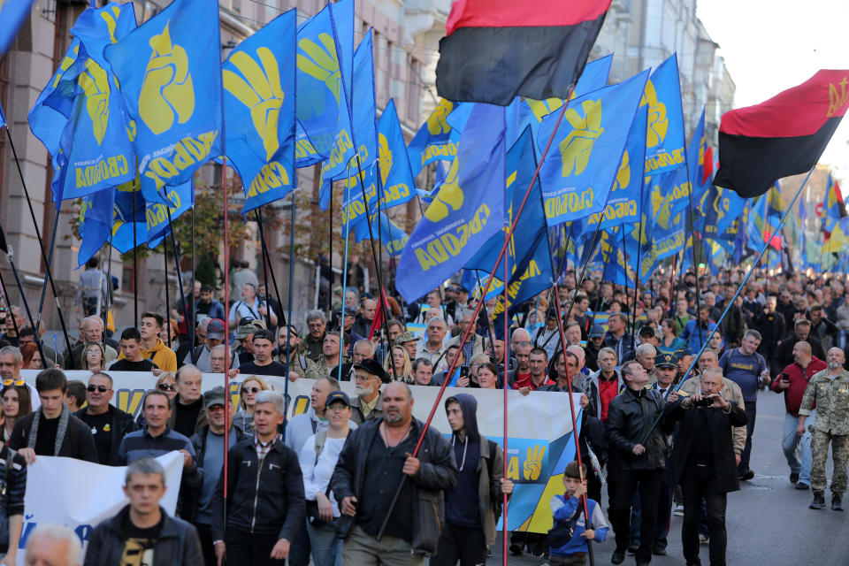 Ukrainians fill a street as they march under the flags of the far-right Svoboda party.