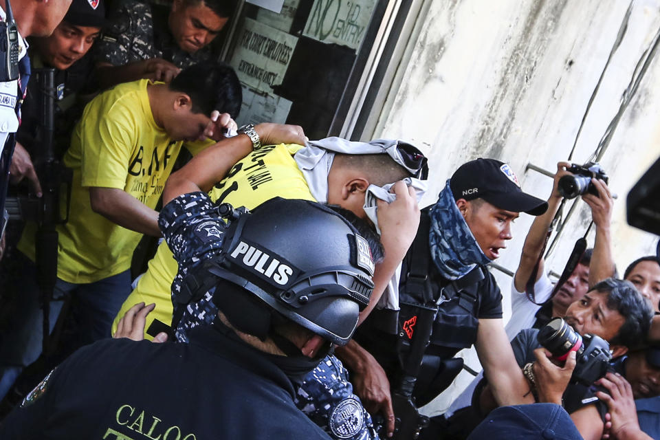 Two of three police officers are escorted out of the courtroom after being found guilty and sentenced up to 40 years without parole for the killing of a student Thursday, Nov. 29, 2018, in suburban Caloocan city, north of Manila, Philippines. The court found the three police officers guilty on Thursday of killing Kian Loyd Delos Santos, a student they alleged was a drug dealer, in the first known such conviction under the president's deadly crackdown on drugs. (AP Photo/Gerard Carreon)