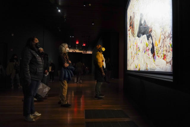People look at a painting from the "Kehinde Wiley: An Archaeology of Silence," exhibition at the de Young Museum in San Francisco, Friday, March 24, 2023. (AP Photo/Godofredo A. Vásquez)