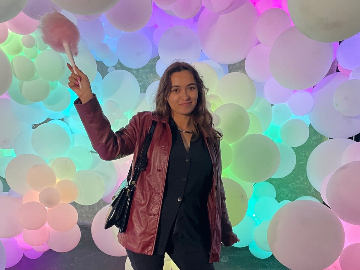 Olivia Hebert posing with cotton candy in front of Molly Balloons’ balloon art installation at the Willy Wonka Experience in Downtown Los Angeles, California on 28 April. (Olivia Hebert)